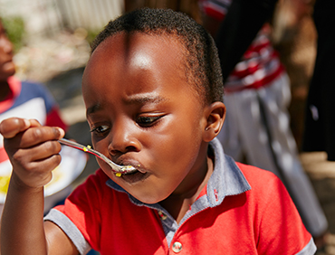 cropped-shot-of-children-getting-fed-at-a-food-out-FQPR2E8